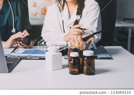 Group of doctors attending seminar in hospital lecture hall with senior physician giving medical presentation and professional training session on healthcare practices 133069310