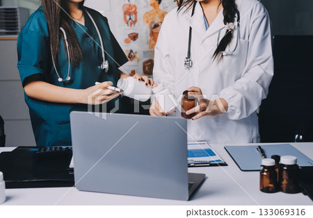 Group of doctors attending seminar in hospital lecture hall with senior physician giving medical presentation and professional training session on healthcare practices 133069316