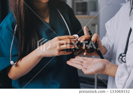 Group of doctors attending seminar in hospital lecture hall with senior physician giving medical presentation and professional training session on healthcare practices Group of doctors attending seminar in hospital lecture hall with senior physician giving medical presentation and professional training session on healthcare practices 133069332