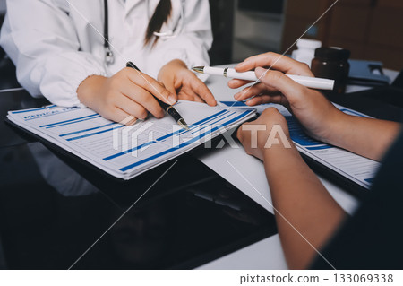 Group of doctors attending seminar in hospital lecture hall with senior physician giving medical presentation and professional training session on healthcare practices 133069338