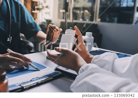 Group of doctors attending seminar in hospital lecture hall with senior physician giving medical presentation and professional training session on healthcare practices 133069342