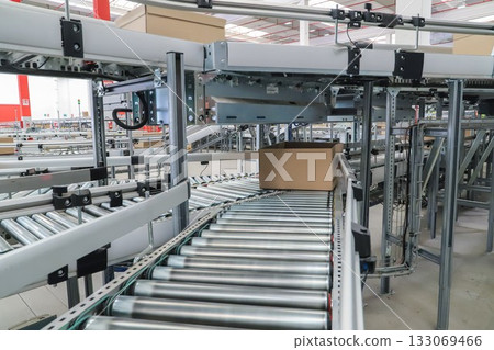 packing line in a logistics warehouse. conveyor belt in a modern production line packing line in a logistics warehouse. conveyor belt in a modern production line 133069466