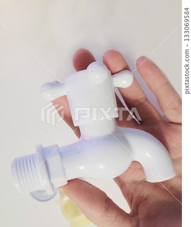White Plastic Faucet Held in Human Hand White Plastic Faucet Held in Human Hand 133069584