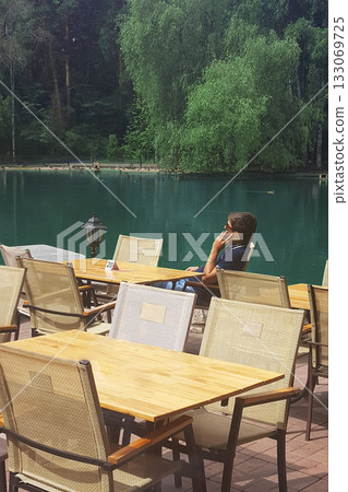 Lakeside Cafe: A Man Phone Call Amidst Nature 133069725