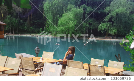 Lakeside Cafe: A Man Phone Call Amidst Nature 133069726