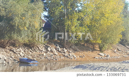 Lakeside Landscape with Boat and Rocky Shore 133069731