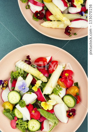 mixed greens salad with edible flowers. 133070156