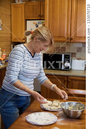 Senior Woman Cooking: Rustic Kitchen and Dough Preparation Senior Woman Cooking: Rustic Kitchen and Dough Preparation 133070710