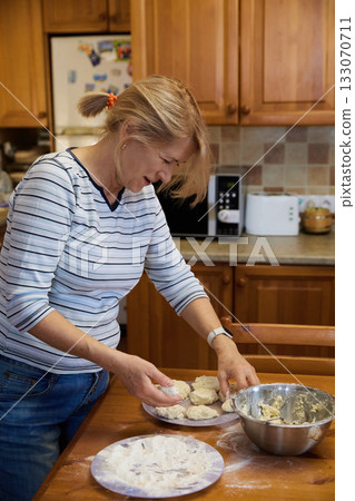Senior Woman Cooking: Rustic Kitchen and Dough Preparation 133070711