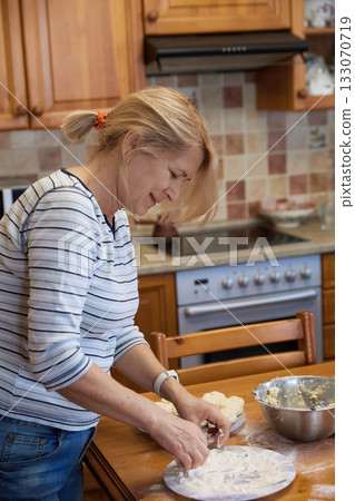 Senior Woman Cooking: Rustic Kitchen and Dough Preparation 133070719