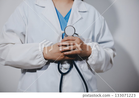 A young male doctor holding an stethoscope A young male doctor holding an stethoscope 133071223