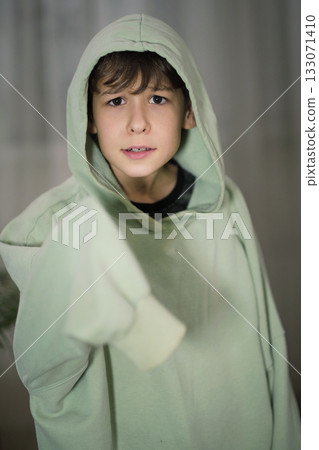 Portrait of a child wearing an oversized hoodie, showcasing a thoughtful and inquisitive expression. Portrait of a child wearing an oversized hoodie, showcasing a thoughtful and inquisitive expression. 133071410
