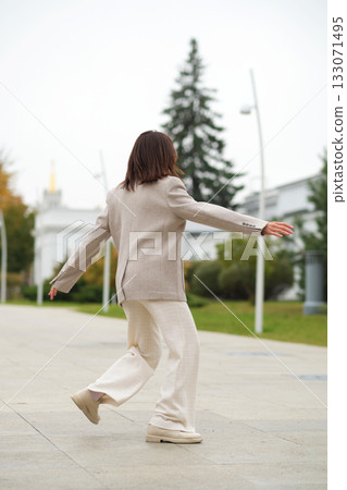 A senior woman twirls in place, smiling brightly as her coat flows. It reflects emotional well-being, freedom from judgment, and the stylish face of active aging. A senior woman twirls in place, smiling brightly as her coat flows. It reflects emotional well-being, freedom from judgment, and the stylish face of active aging. 133071495