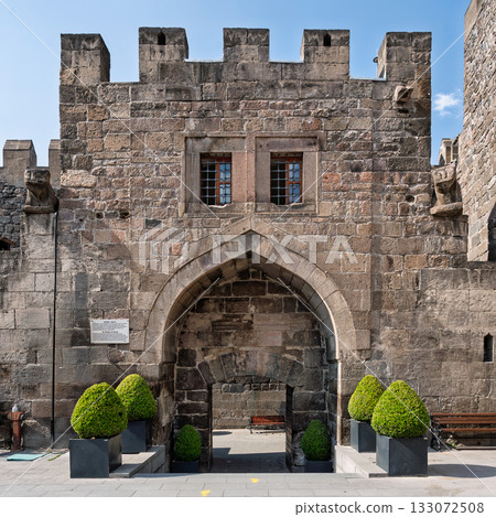 Ancient Kayseri Castle stone wall featuring an arched entrance, barred windows, and battlements, Kayseri, Turkey 133072508