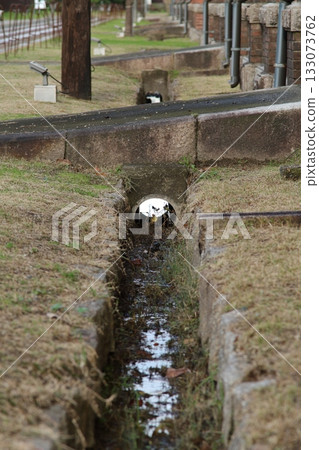 A ditch next to an old building A ditch next to an old building 133073762