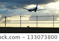 Airplane landing at airport with security fence at sunset, travel concept 133073800