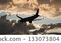 Airplane approaching airport runway for landing at beautiful sunset with dramatic clouds 133073804