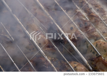 marinated pork meat with spices during cooking on the grill, pork on the grill with high heat and smoke marinated pork meat with spices during cooking on the grill, pork on the grill with high heat and smoke 133075601
