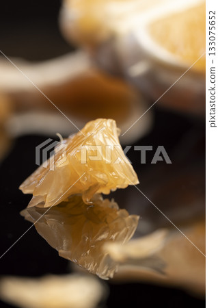 orange citrus on a black mirror surface, ripe and sweet and juicy citrus is reflected on the black surface, close up 133075652