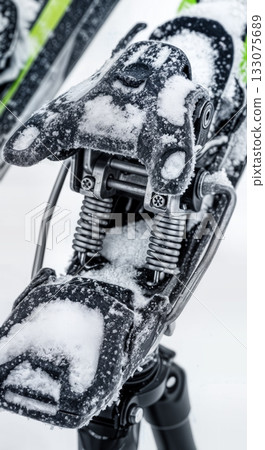 Macro of ski binding mechanism packed with fresh snow showing springs and metal components technical winter gear Macro of ski binding mechanism packed with fresh snow showing springs and metal components technical winter gear 133075689