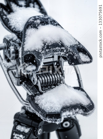 Macro of ski binding mechanism packed with fresh snow showing springs and metal components technical winter gear Macro of ski binding mechanism packed with fresh snow showing springs and metal components technical winter gear 133075691