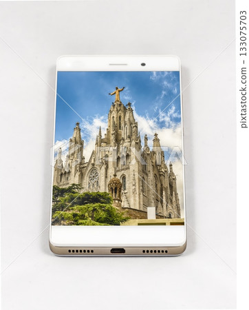 Smartphone displays Sagrat Cor church, Barcelona, with Christ statue against Smartphone displays Sagrat Cor church, Barcelona, with Christ statue against 133075703