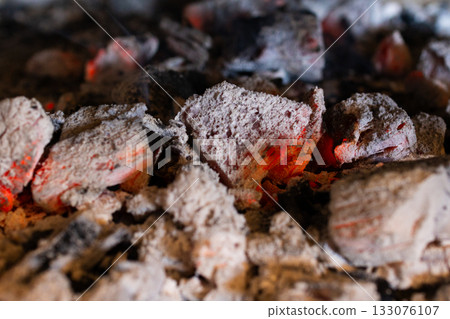Close-up photo of hot embers and glowing charcoal briquettes radiating intense heat. Roasting. Representing fire ready for action. Close-up photo of hot embers and glowing charcoal briquettes radiating intense heat. Roasting. Representing fire ready for action. 133076107
