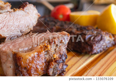 Close-up photo of a grilled chorizo steak on a rustic wooden board, fresh meat served hot and just prepared. 133076109