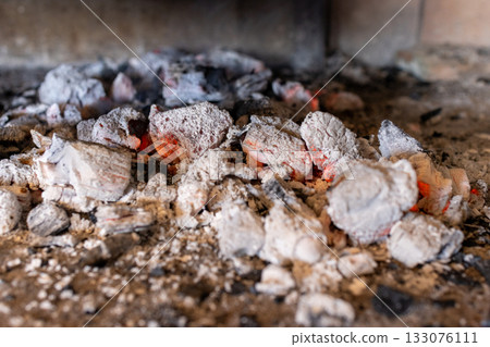 Red-hot embers and hot charcoal briquettes are ready to cook food on a barbecue .Horizontal real picture. Red-hot embers and hot charcoal briquettes are ready to cook food on a barbecue .Horizontal real picture. 133076111