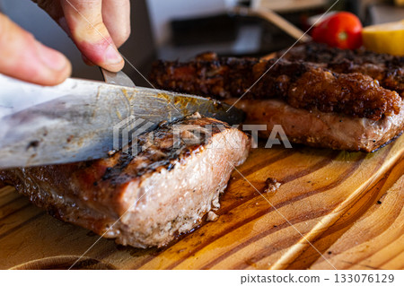 Succulent barbecued chorizo steak on a rustic wooden board, fresh meat served hot and freshly cooked 133076129