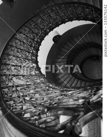 Black and white spiral staircase with ornate iron railing viewed from above Black and white spiral staircase with ornate iron railing viewed from above 133076142