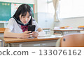 高中女生在教室裡專心致志地看著智慧型手機螢幕 133076162