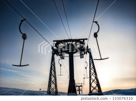 Ski lift towers and cables silhouetted against dramatic winter sky low angle industrial alpine infrastructure Ski lift towers and cables silhouetted against dramatic winter sky low angle industrial alpine infrastructure 133076310