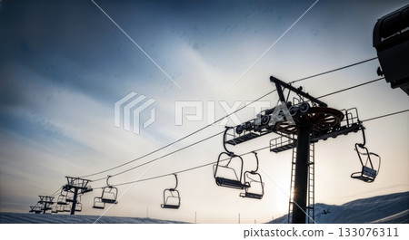 Ski lift towers and cables silhouetted against dramatic winter sky low angle industrial alpine infrastructure Ski lift towers and cables silhouetted against dramatic winter sky low angle industrial alpine infrastructure 133076311