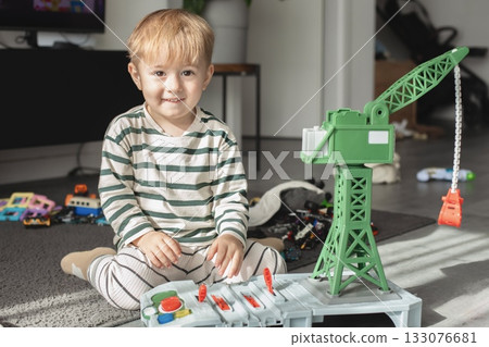 The child is focused on imaginative play, developing creativity and motor skills. Bright natural light and cozy atmosphere make this image perfect for illustrating childhood, learning through play The child is focused on imaginative play, developing creativity and motor skills. Bright natural light and cozy atmosphere make this image perfect for illustrating childhood, learning through play 133076681