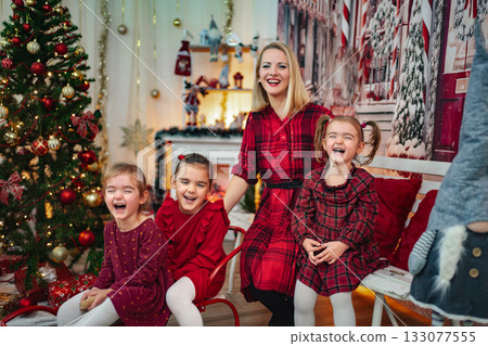 Mother and three daughters laughing enjoying Christmas holiday together 133077555