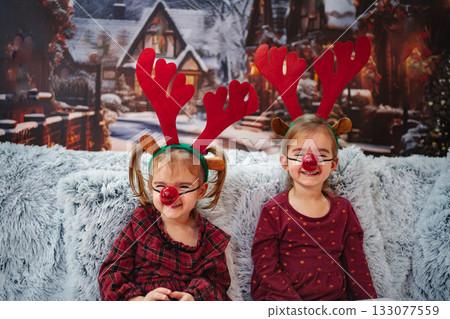 Little girls wearing reindeer costumes celebrating Christmas holiday 133077559