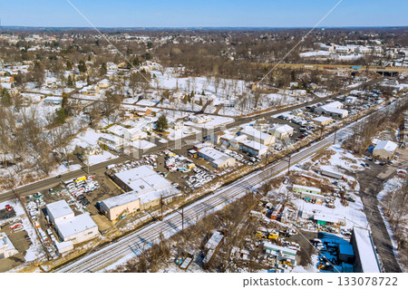 Winter landscape over snowy town showing businesses railway tracks in suburban area Winter landscape over snowy town showing businesses railway tracks in suburban area 133078722