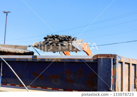 Construction equipment loads asphalt debris into large truck Construction equipment loads asphalt debris into large truck 133078723