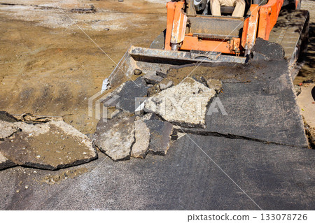 Construction crew working on road repair using heavy machinery in daytime Construction crew working on road repair using heavy machinery in daytime 133078726