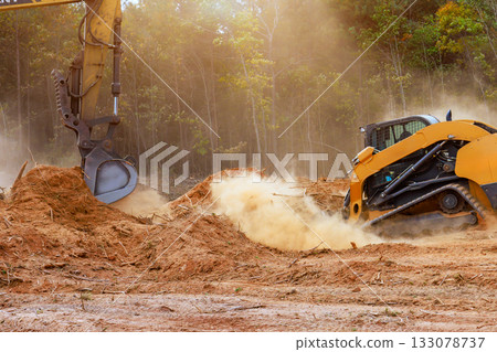 Heavy machinery clearing land at construction site of forest setting 133078737