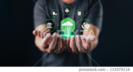 A person holds out their hands beneath glowing eco icons and a green CO2 cloud symbol, representing environmental sustainability, carbon reduction, and clean energy initiatives. A person holds out their hands beneath glowing eco icons and a green CO2 cloud symbol, representing environmental sustainability, carbon reduction, and clean energy initiatives. 133079116