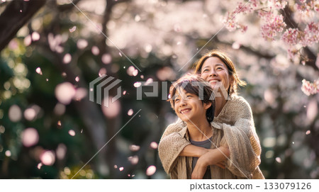 春天，母親和兒子在櫻花盛開的公園裡玩耍。 133079126