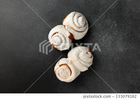 Fragrant Cinnabons with cream on a gray background 133079162