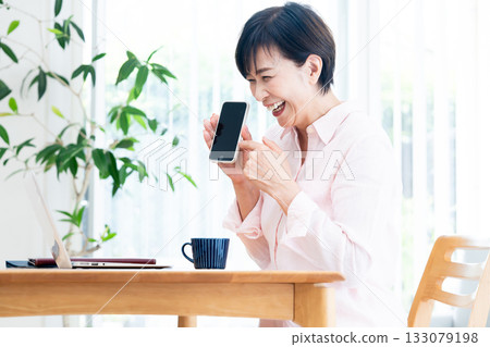 Middle-aged woman teleworking in the living room 133079198