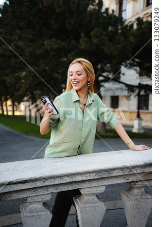 Happy woman smiling watching content on smartphone in Vienna 133079249