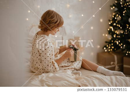 Child with Gift Box Amid Christmas Tree Decorations 133079531