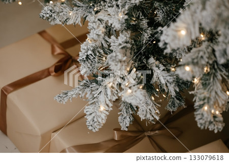 Christmas Presents Under Snowy Christmas Tree with Lights 133079618