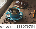 A blue cup of hot black coffee and a notebook on a wooden table by the window 133079764