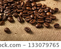 Close-up photo of fragrant roasted coffee beans spread on a linen cloth 133079765